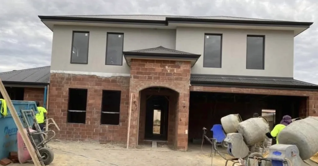 Before: two-storey home with the lower storey in bare brick