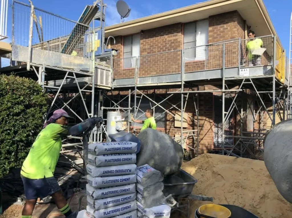 Plastering crew working beside scaffolding