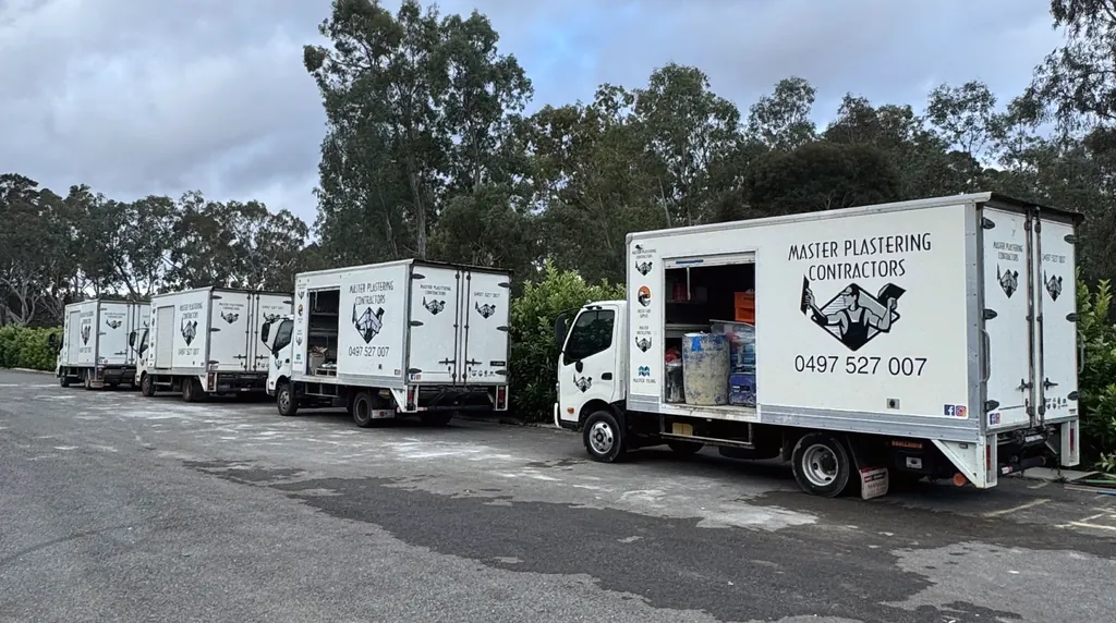 Master Plastering trucks and trailer in the yard