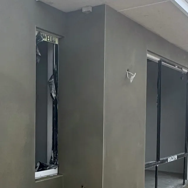 Detail of olive-grey render around a window
